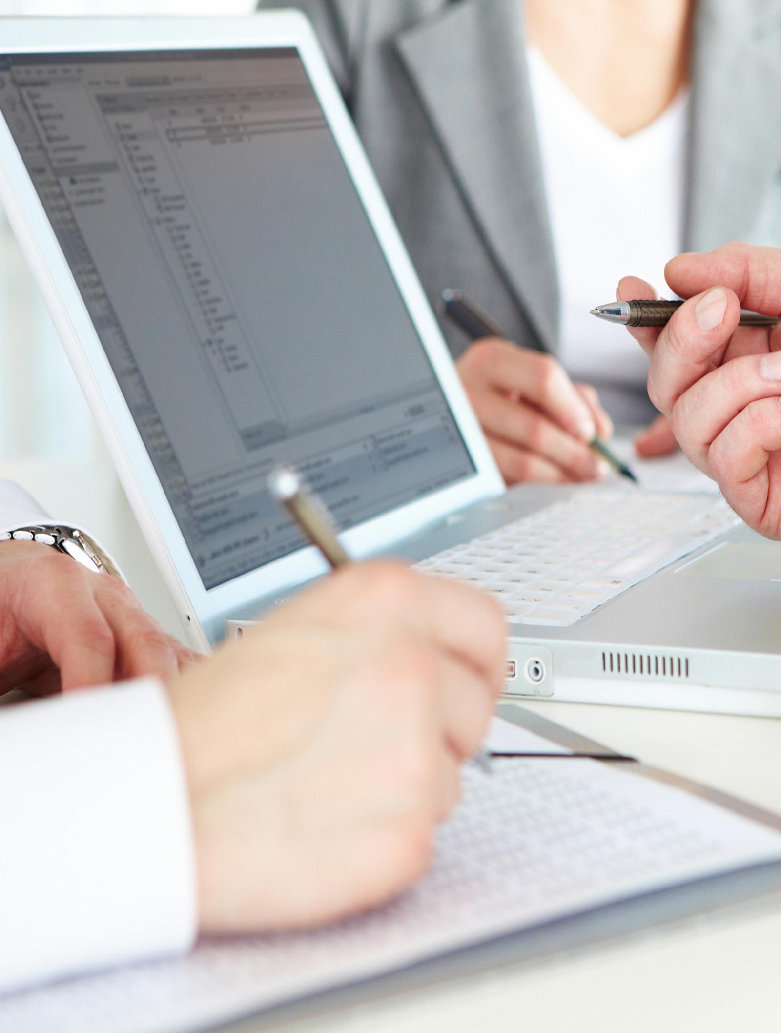 Rates and Fees for Signature Loans. A group of people sitting at a table with laptops.